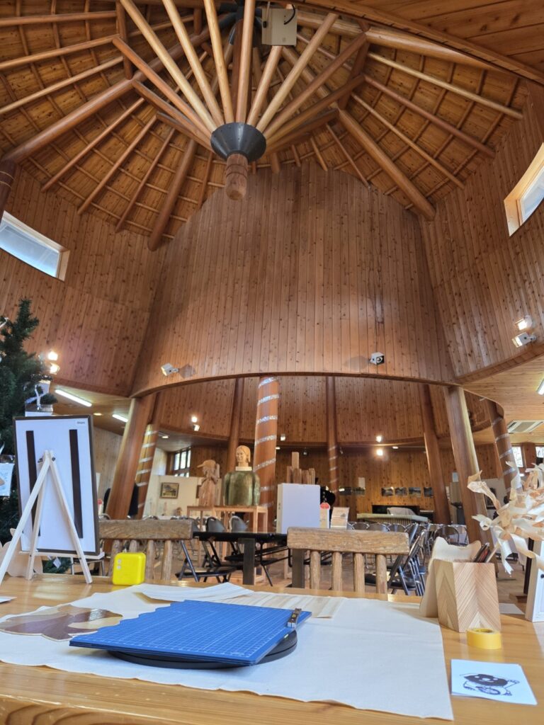 自然光が差し込むもくもくランド物産館の建物。ピアノの演奏と木のぬくもりを感じながら、この空間で木の切り絵を実演。