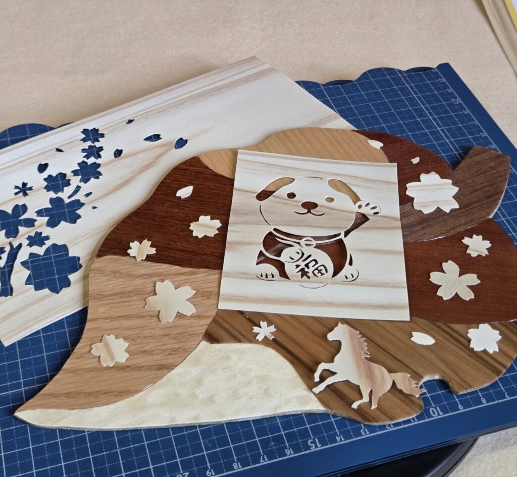 木象嵌の技法で制作した「木の葉っぱコースター」の上に飾られた、犬のシルエットの木の切り絵作品『わんこのワルツ』。